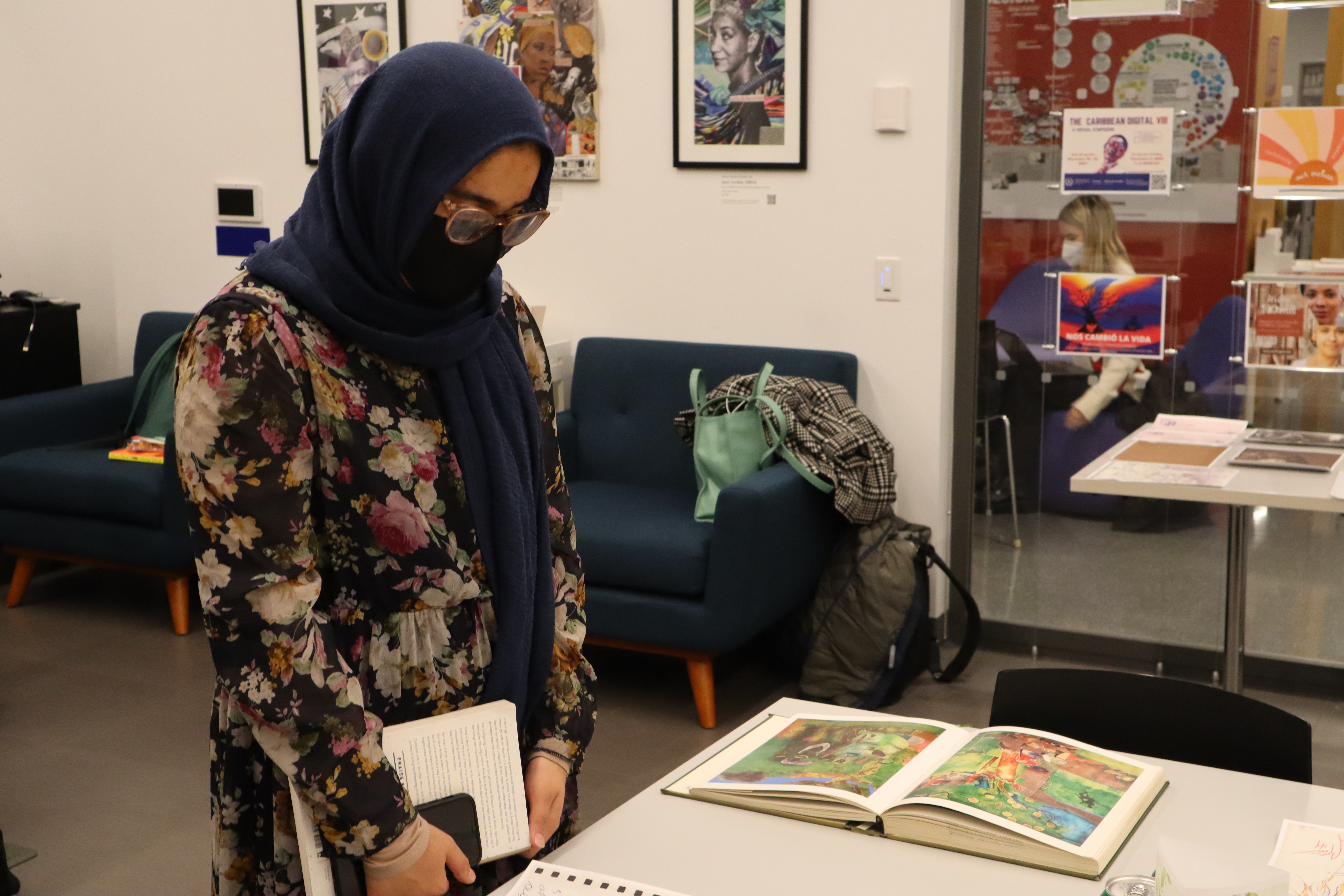 One person looks through archival materials used in the DHC's Collaborative collage