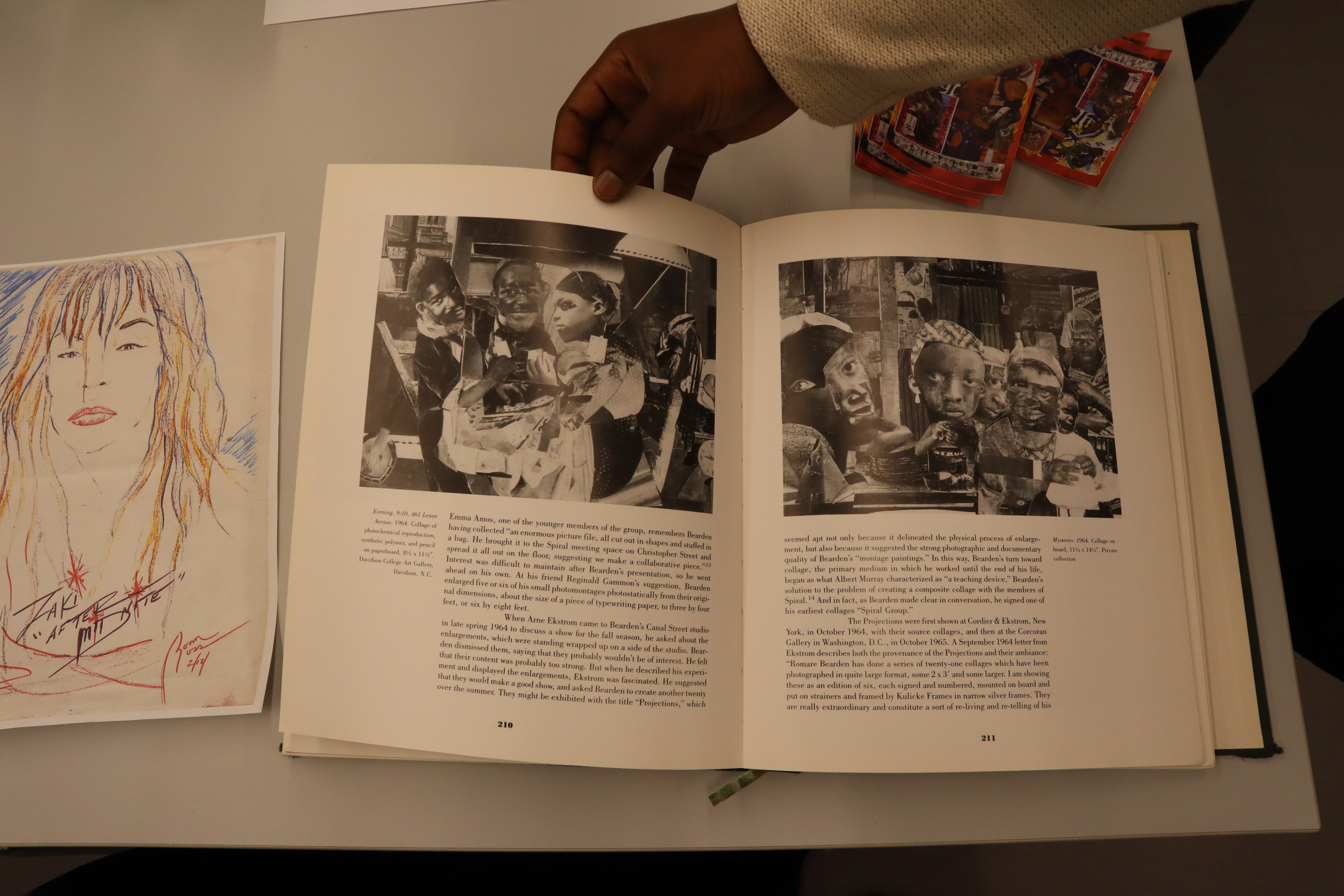 A hand flips through archival materials used in the DHC Collaborative collage 
